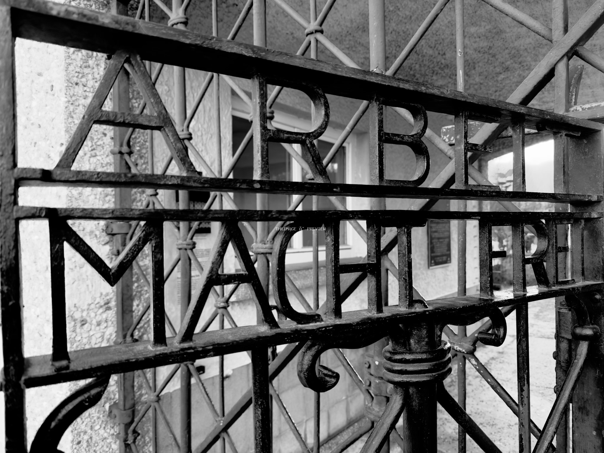 Arbeit Macht Frei iron gate at Dachau Concentration Camp Memorial Site photographed in black and white.