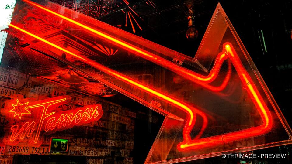Red neon star and arrow inside an urban venue