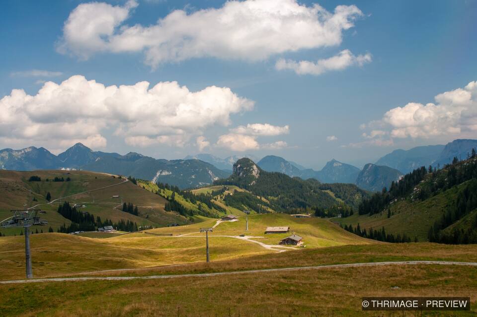 Alpine valley and mountain peaks beneath summer clouds