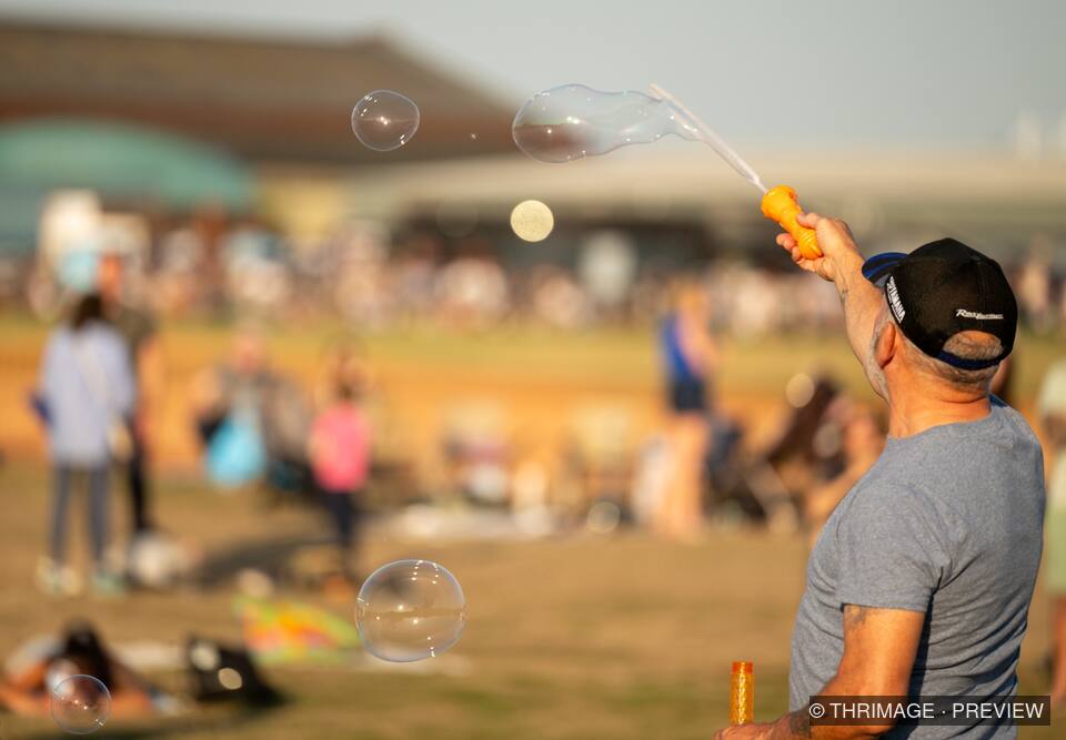 Man creating soap bubbles at an outdoor community event